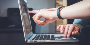 fingers pointing at a computer screen