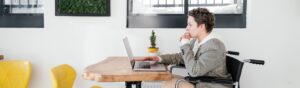 woman in wheelchair looking at a laptop
